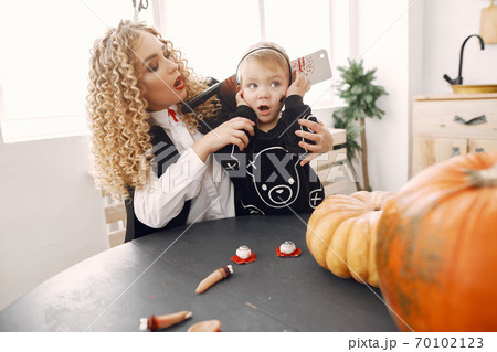 Family in costumes getting ready for halloween at home 70102123
