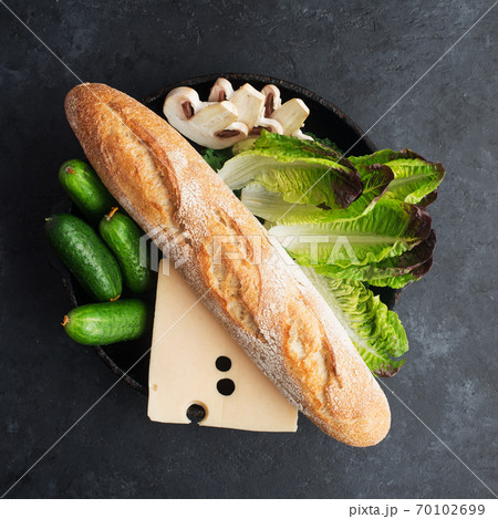 Baguette cheese vegetables ingredients for a fresh crispy sandwich for breakfast or a snack for the whole family. Healthy and comfortable food. Top view. Flat lay, Baguette cheese vegetables ingredients for a fresh crispy sandwich for breakfast or a snack for the whole family. Healthy and comfortable food. Top view. Flat lay, 70102699