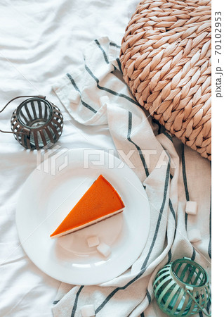 Cheesecake with caramel on a white plate in bed in the room. Vertical photo orientation 70102953