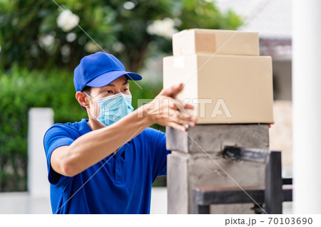 Asian deliver man make contactless package delivery to customer. 70103690