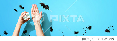 Applying sanitizer gel with Halloween theme 70104349