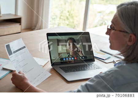 Old female hr employer hr reading cv during online job interview by video call. 70106883