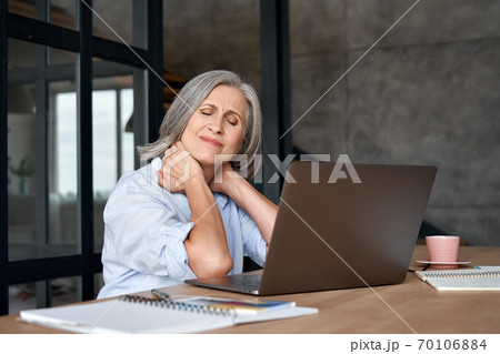 Tired stressed older mature business woman suffering from neck pain. 70106884