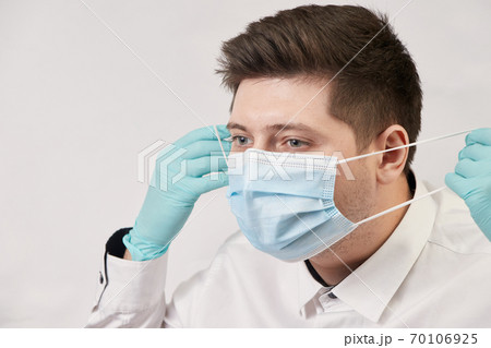 coronavirus concept, man putting on protective medical mask on white background 70106925