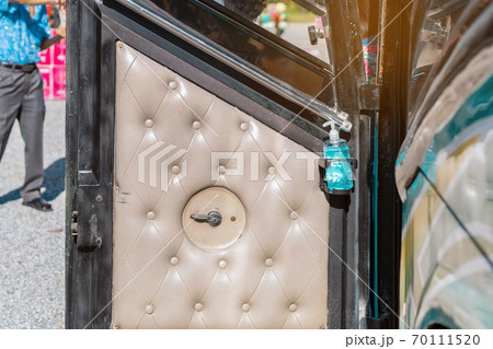 Blue alcohol gel bottle hanging on the door of the double-decker bus to serve passengers and prevent the spread of Corona Virus (Covid-19). Travel safely on public transport. New normal lifestyle. 70111520