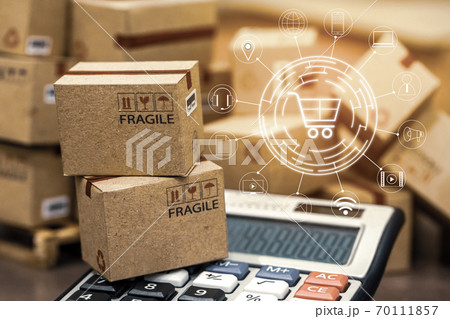 Business finance: Packaging small paper boxes on wood pallet with calculator. Ideas for assembling a portfolio of assets which are held directly by investors. 70111857