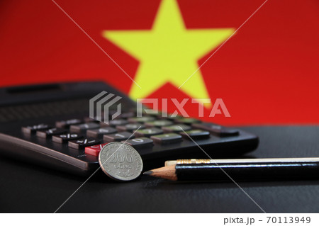 Two hundred Vietnam Dong coin on reverse (VND) with black calculator and two pencils 70113949