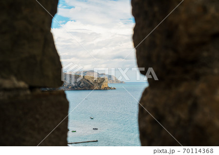 View of the sea coast through the window in the fortress. View of the sea coast through the window in the fortress. 70114368