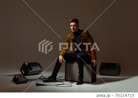 singer sitting on a musical column in the studio singer sitting on a musical column in the studio 70114715
