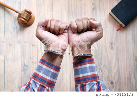 hands of a man with handcuffs close up. 70115173