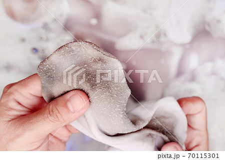 Woman washing dirty white socks by hand. 70115301