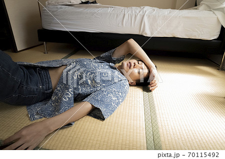 畳に寝転ぶ男性 70115492