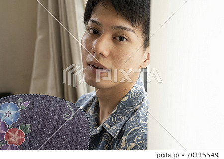 うちわであおぐ男性 70115549