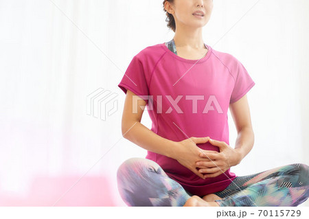 胡座をかいてお腹を触る妊婦 胡座をかいてお腹を触る妊婦 70115729
