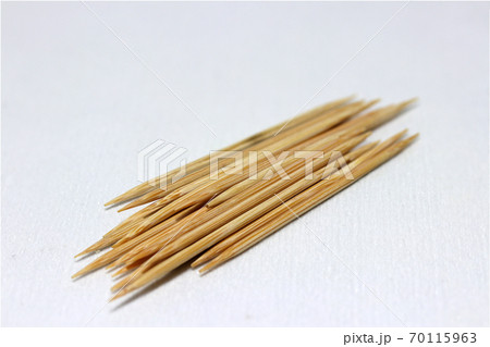 Pile of wooden toothpick put on the white floor. it is a short pointed piece of wood Pile of wooden toothpick put on the white floor. it is a short pointed piece of wood 70115963