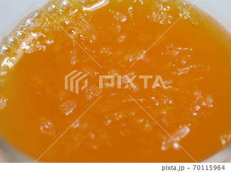 Close up orange juice in the glass. A glass of juice, the liquid obtained from orange. Close up orange juice in the glass. A glass of juice, the liquid obtained from orange. 70115964