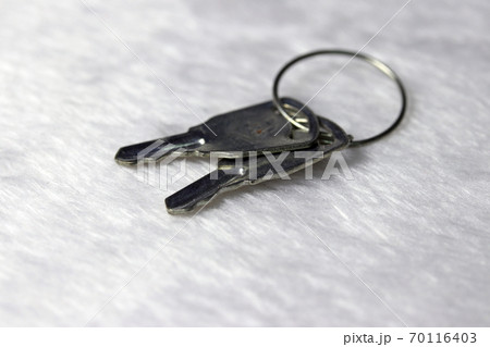 Mini metal two keys put on the white fabric floor. 70116403