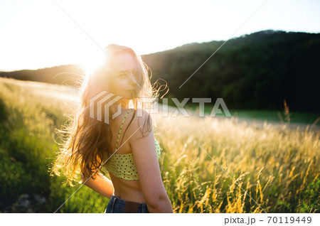 Portrait of young teenager girl outdoors in nature at sunset. 70119449