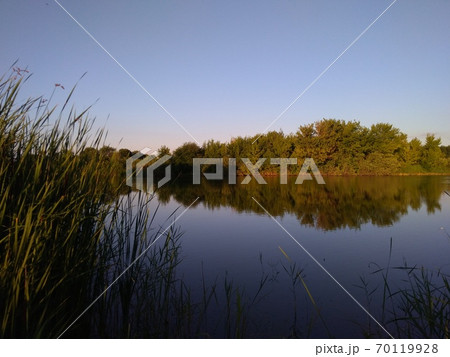 Fishing at sunset, reflection in the water Fishing at sunset, reflection in the water 70119928