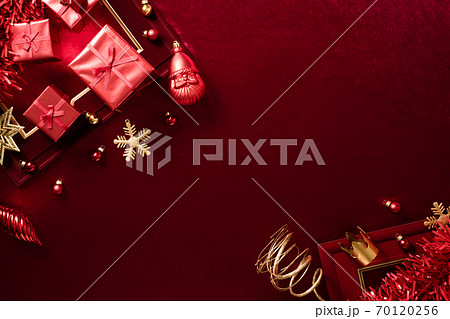 red christmas decoration bauble and ribbon on velvet red felt fabric  top view table backgorund 70120256