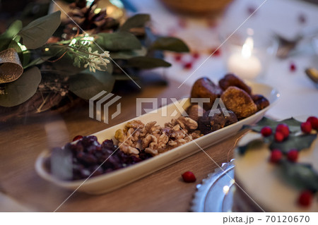 A close-up of dried fruit and nuts on table set for dinner meal at Christmas time. A close-up of dried fruit and nuts on table set for dinner meal at Christmas time. 70120670