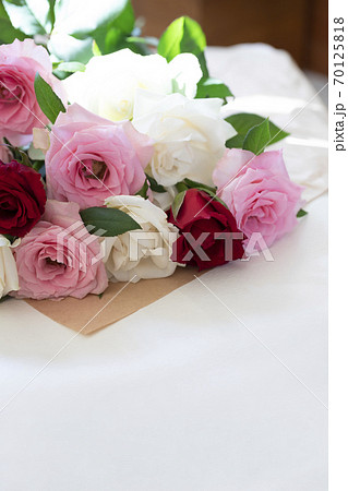ラッピングペーパーの上のカラフルなバラの花束の写真素材