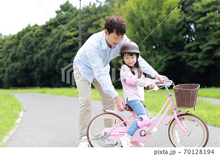自転車の補助輪を取って練習をする親子 70128194