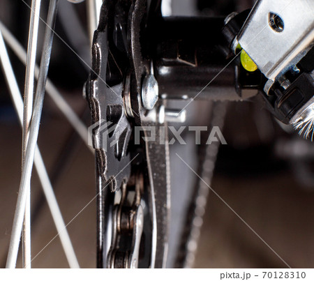 Gearshift on mountain bike MTB, chain moves on rings. Changes speeds. Shift gears on bicycle crank. Work of chain drive chainset. Front derailleur. Macro closeup low angle shot. Wheel spins and turns Gearshift on mountain bike MTB, chain moves on rings. Changes speeds. Shift gears on bicycle crank. Work of chain drive chainset. Front derailleur. Macro closeup low angle shot. Wheel spins and turns 70128310