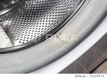 Dirt and fungus from moisture on the sealing gum of the washing machine drum. Washing machine cleanliness and care concept 70128372