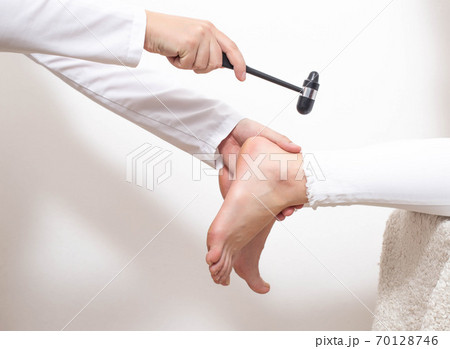 Checking the patient's Achilles reflex for the presence of a compressed nerve with injuries of the spine and spinal cord of an intervertebral hernia, copy space Checking the patient's Achilles reflex for the presence of a compressed nerve with injuries of the spine and spinal cord of an intervertebral hernia, copy space 70128746