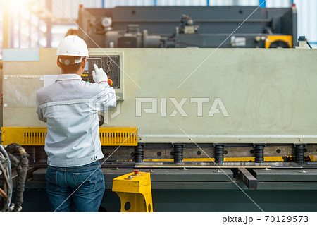 Worker operate hydraulic press brake bending machine in construction factory Worker operate hydraulic press brake bending machine in construction factory 70129573