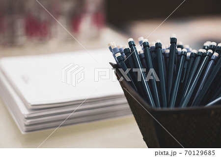 pens and pencils with an eraser on the end on the background of a stack of papers 70129685