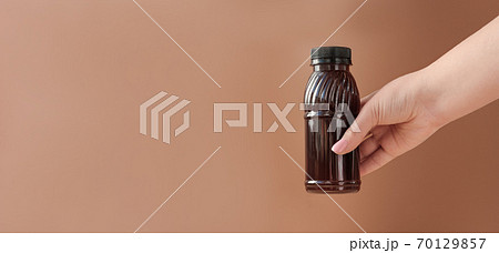Hand holding cold brew coffee.  70129857