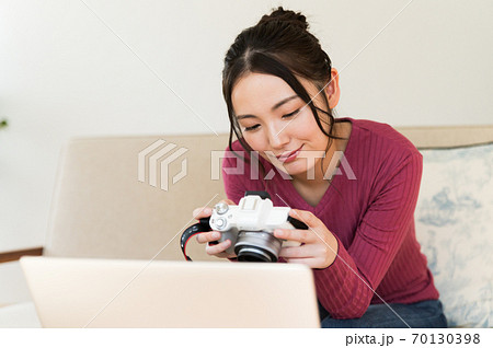 カメラの写真を見ながらパソコンを操作する女性 70130398
