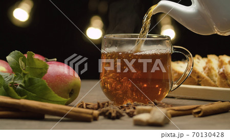 Tea pouring into glass mug 70130428