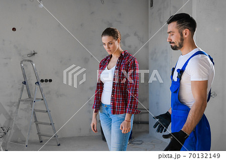 Woman scolds man in blue overalls for bad repair Woman scolds man in blue overalls for bad repair 70132149