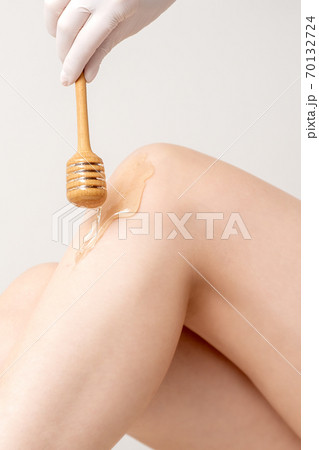 Wax flowing down on female leg 70132724