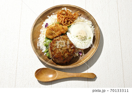 唐揚げやナポリタンも一緒に乗っているワンプレートのロコモコ丼と木製スプーン（俯瞰） 70133311
