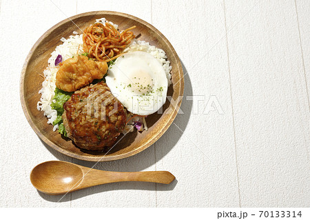 唐揚げやナポリタンも一緒に乗っているワンプレートのロコモコ丼と木製スプーン（俯瞰） 70133314