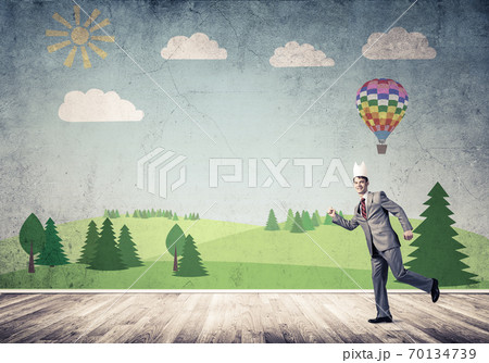 King businessman in elegant suit running in empty room with nature drawing on wall 70134739