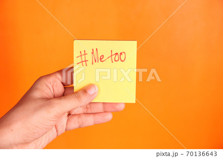young woman showing a note with the text me too. young woman showing a note with the text me too. 70136643