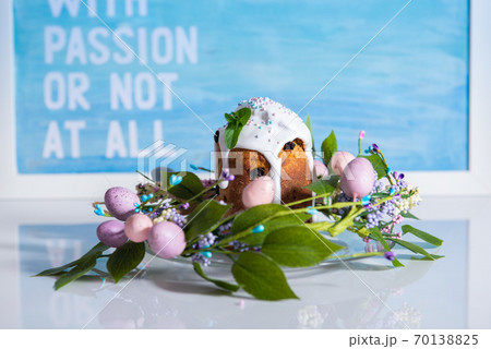 Easter cake in the center of a wreath of spring flowers on a blue vintage background with copy space 70138825