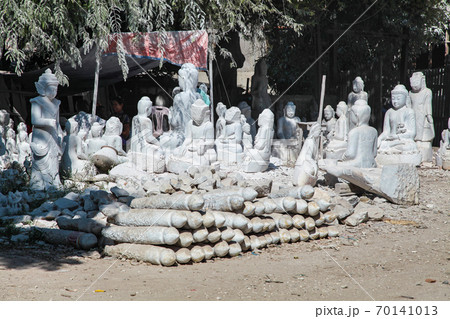 carving Buddha statues from stone in a street workshop in Mandalay, Myanmar 70141013