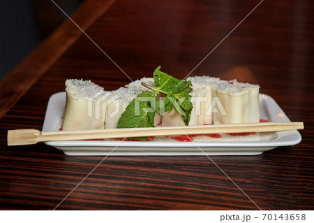 White dish with Japanese minari dessert and wooden chopsticks 70143658