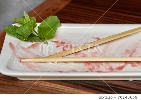 Empty rectangular plate with leftover sauce and wooden chopsticks 70143659