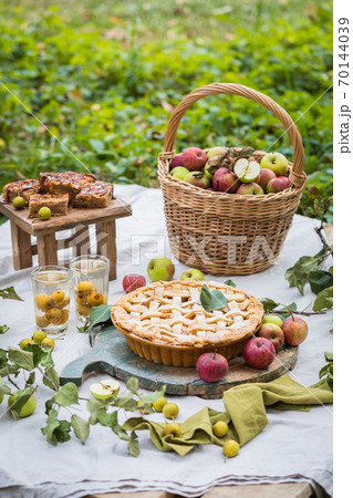 Freshly baked apple pie with stewed fruit glasses and tree branches 70144039