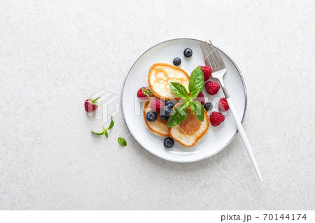 Pancakes with fresh blueberry and raspberry served for healthy vegetarian breakfast 70144174