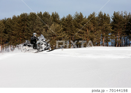 In deep powder snowdrift snowmobile rider driving fast. In deep powder snowdrift snowmobile rider driving fast. 70144198