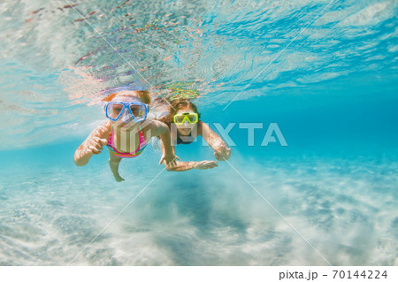 Kids in snorkeling mask dive underwater in blue sea lagoon Kids in snorkeling mask dive underwater in blue sea lagoon 70144224