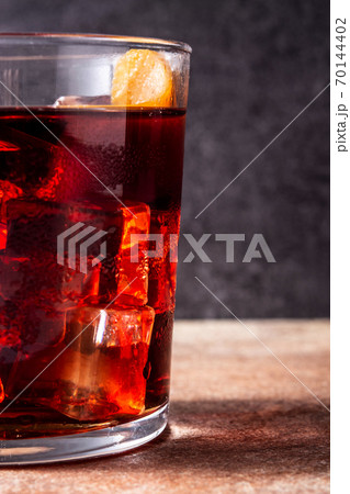 Boulevardier cocktail and orange zest on rusty background 70144402
